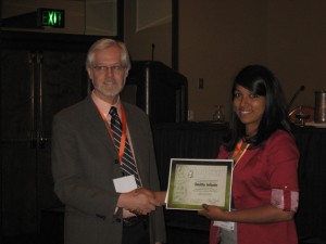 President Chip Vorhees presents Smitha Infante with her award